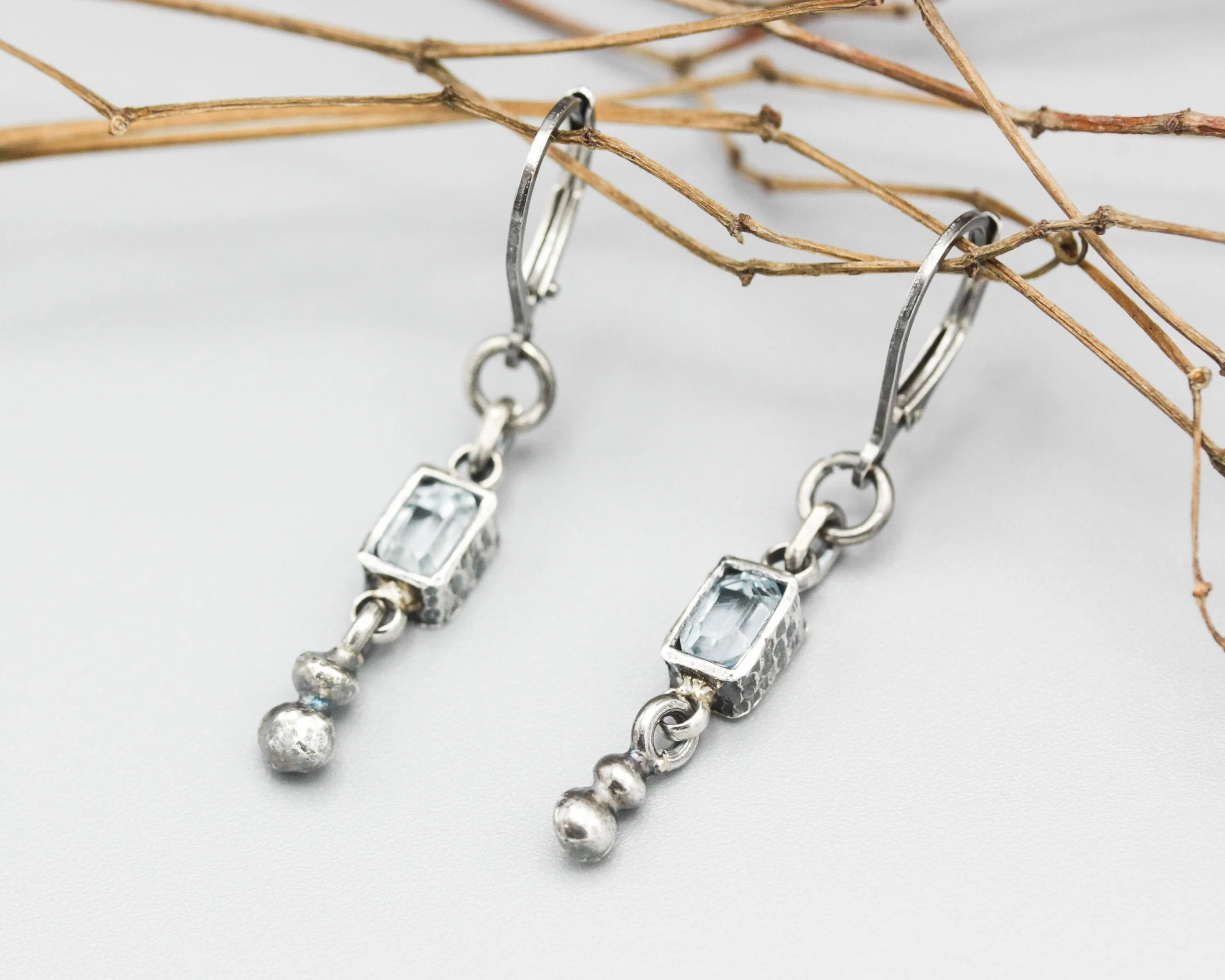 Earrings Princess cut Swiss blue topaz in silver bezel setting with silver peanut on sterling silver hooks style
