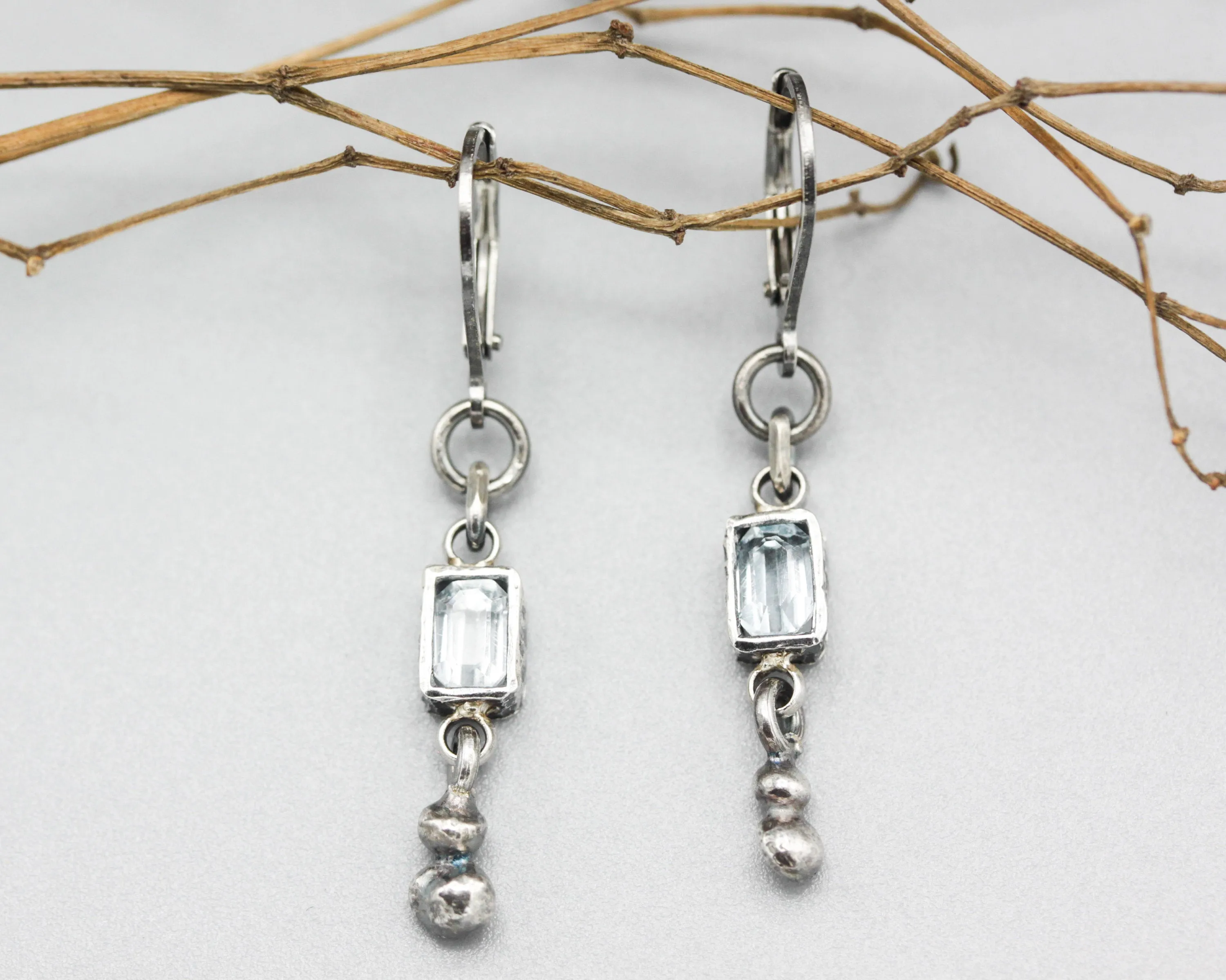 Earrings Princess cut Swiss blue topaz in silver bezel setting with silver peanut on sterling silver hooks style