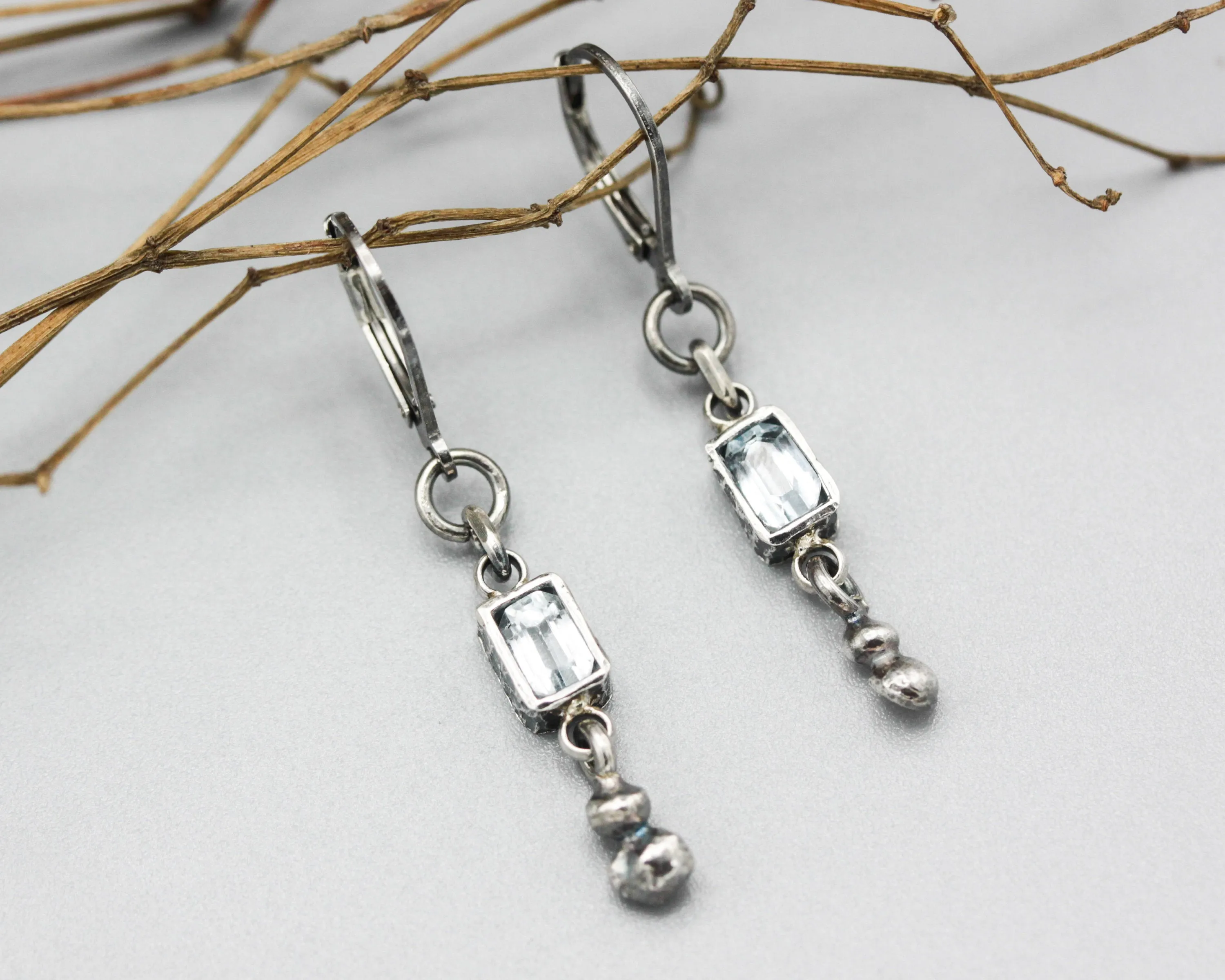 Earrings Princess cut Swiss blue topaz in silver bezel setting with silver peanut on sterling silver hooks style